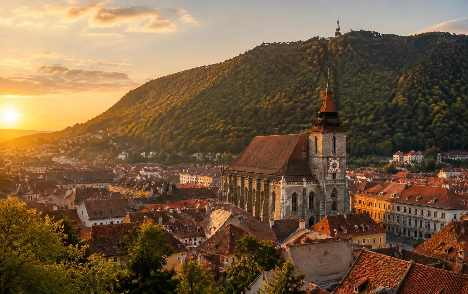 Brașov Old Town and the Black Church beneath Tâmpa mountain at sunset